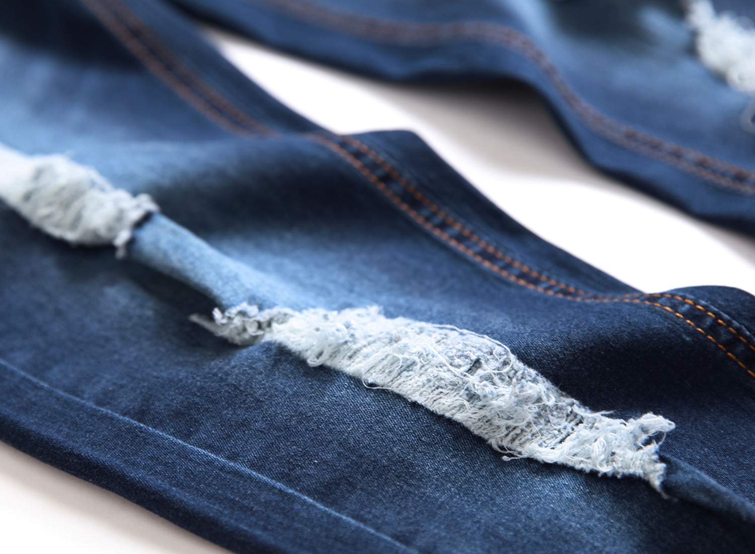 Мужские джинсы с разрывами и зауженными штанинами оптом из Китая