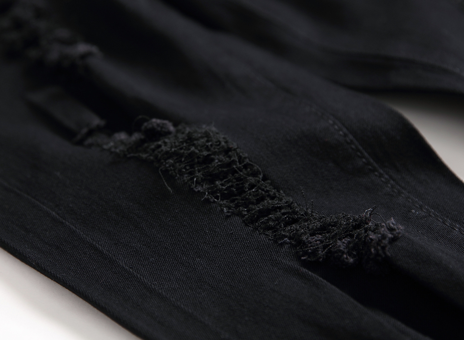 Мужские джинсы с разрывами и зауженными штанинами оптом из Китая